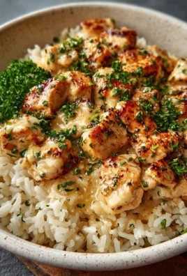 Creamy garlic chicken rice bowls featuring tender chicken and rich sauce.