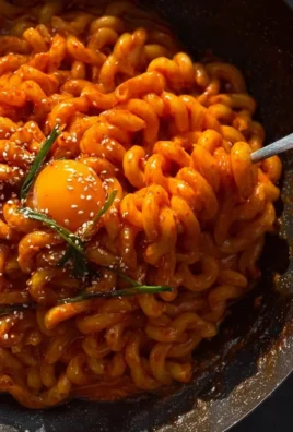 Delicious creamy Gochujang pasta garnished with fresh herbs.