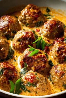 Creamy Tuscan low carb meatballs plated garnished with herbs