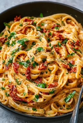 Creamy vegan sun-dried tomato pasta served in a bowl with fresh herbs