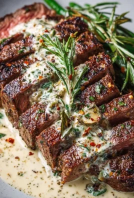 Juicy garlic butter steak topped with creamy parmesan sauce on a plate