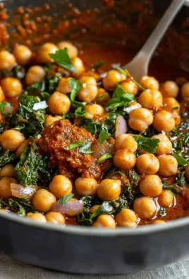 A bowl of flavorful Harissa Chickpeas garnished with herbs.