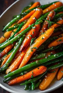 Honey glazed carrots served with green beans in a colorful dish.