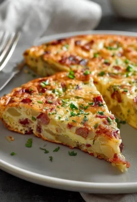 Ina Garten's bacon potato frittata served on a plate with herbs