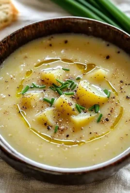 Bowl of Ina Garten's roasted potato leek soup garnished with herbs