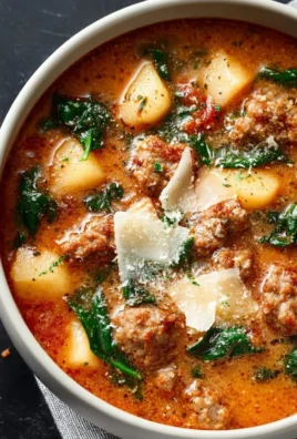 Bowl of Italian Sausage Soup with vegetables and herbs