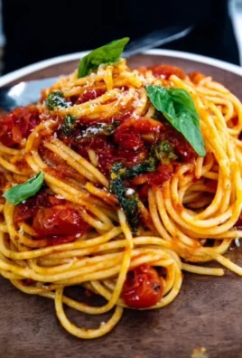 Delicious plate of pasta with vibrant tomato sauce topped with basil.