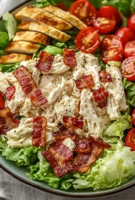 Savory BLT Chicken Salad with crispy bacon, lettuce, and tomatoes on a white plate
