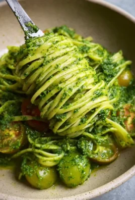 Bowl of Summer Linguine with vibrant spinach pesto garnished with fresh herbs