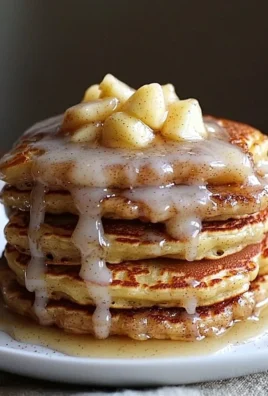 Fluffy apple fritter pancakes topped with syrup and cinnamon.