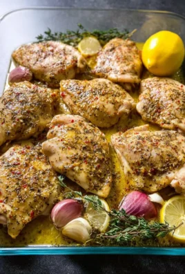Baked Greek Lemon Chicken garnished with fresh herbs and lemon slices