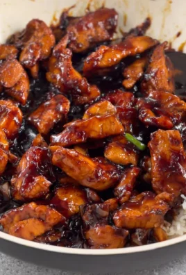 Savory Bourbon Chicken garnished with green onions on a plate