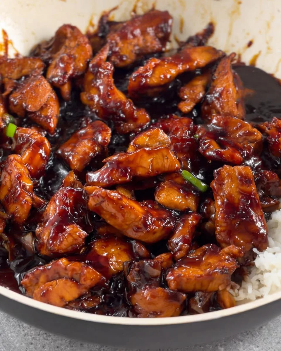 Savory Bourbon Chicken garnished with green onions on a plate