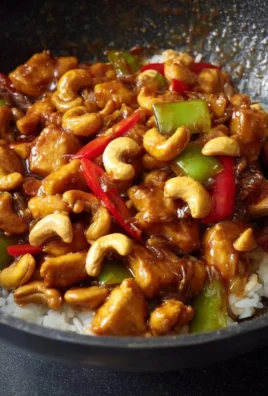 Delicious cashew chicken served with vegetables and rice on a plate.