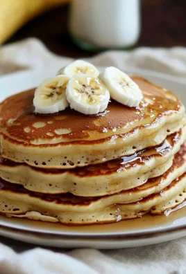 Fluffy banana pancakes served with syrup and fresh fruit