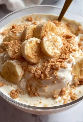 High protein banana pudding bowl topped with fresh bananas and whipped cream