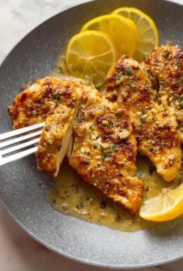 Lemon Garlic Parmesan Chicken served on a plate garnished with herbs.