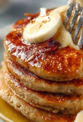 Delicious vegan banana pancakes served with fresh fruit on a plate.