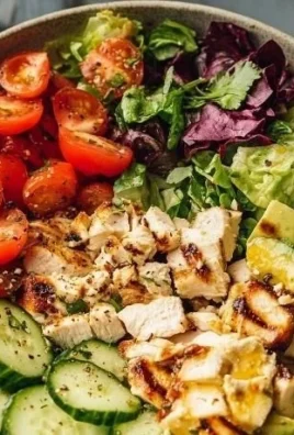 Delicious grilled chicken salad with fresh vegetables and dressing.