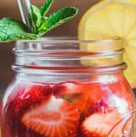 Refreshing strawberry lemonade in a glass garnished with fresh strawberries and lemons