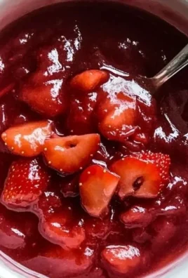Homemade strawberry rhubarb sauce in a jar with fresh strawberries and rhubarb stalks
