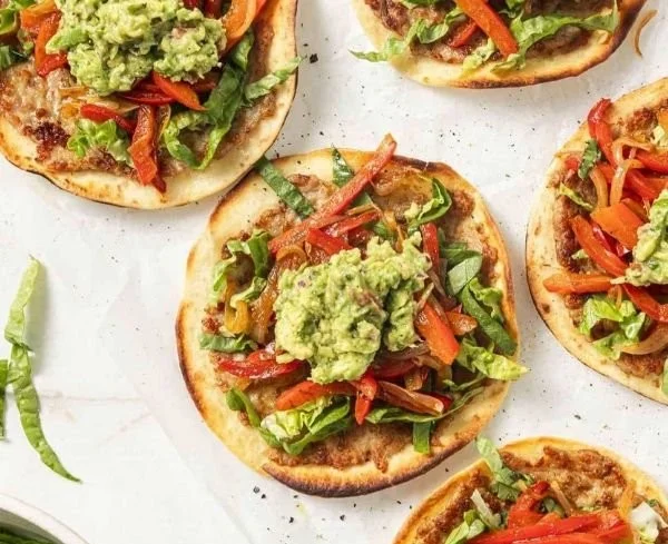 Chicken fajita smashburger tacos served on a plate with fresh toppings.
