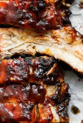 Delicious grilled ribs served with barbecue sauce on a wooden platter