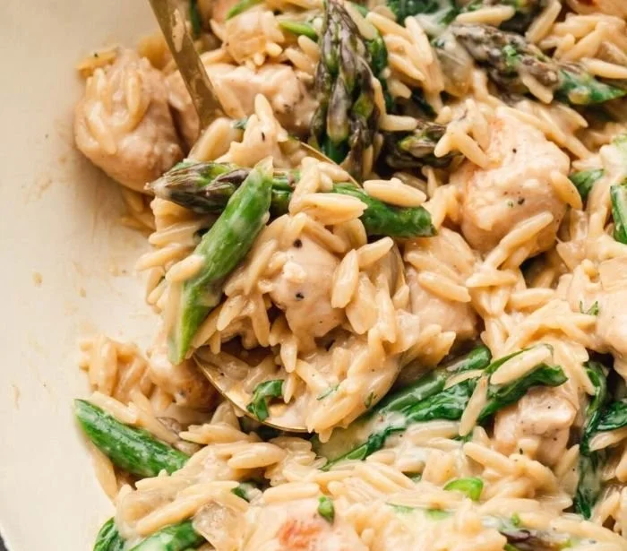 High protein chicken orzo dish garnished with herbs and vegetables