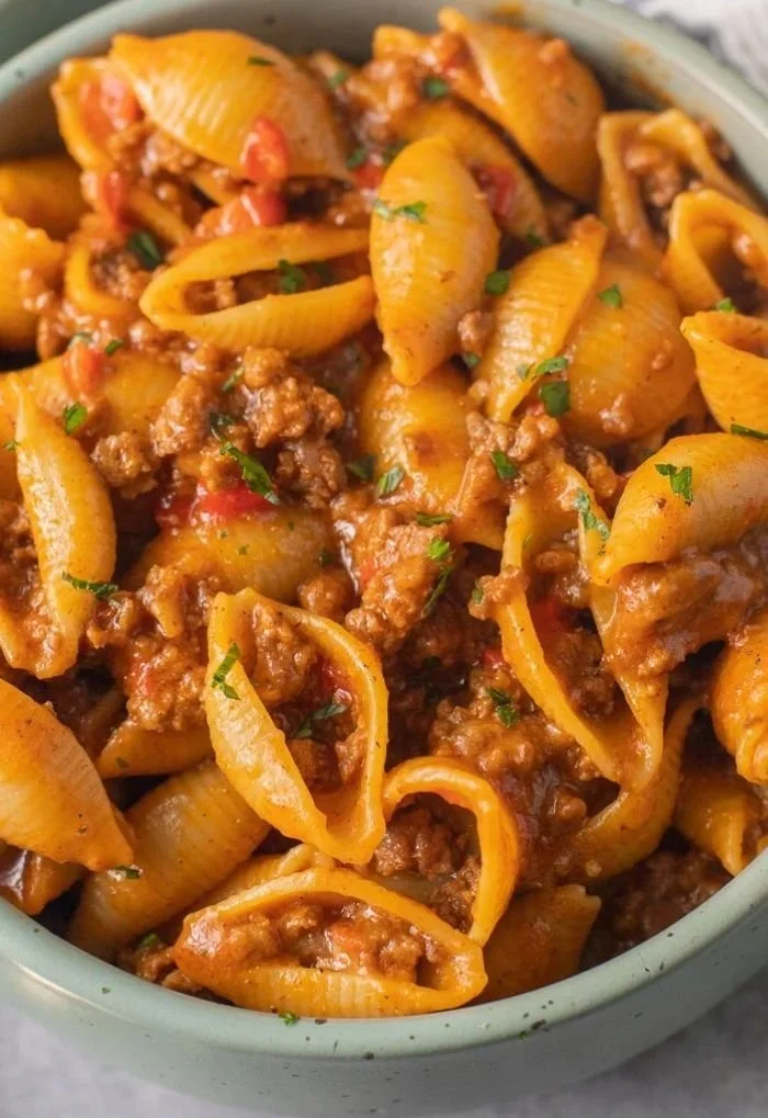 High protein taco pasta bowl garnished with fresh herbs and cheese