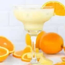 Orange, Pineapple & Coconut mocktail in a glass with tropical garnishes