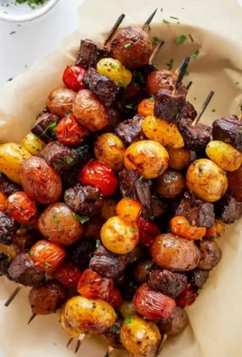 Rosemary garlic steak kebabs grilling on skewers with herbs