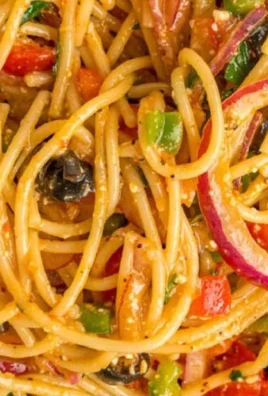 Colorful spaghetti salad with fresh vegetables and dressing