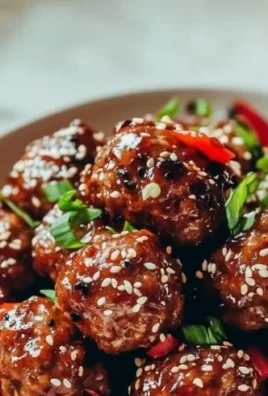 Asian meatballs served with dipping sauce and garnished with green onions.