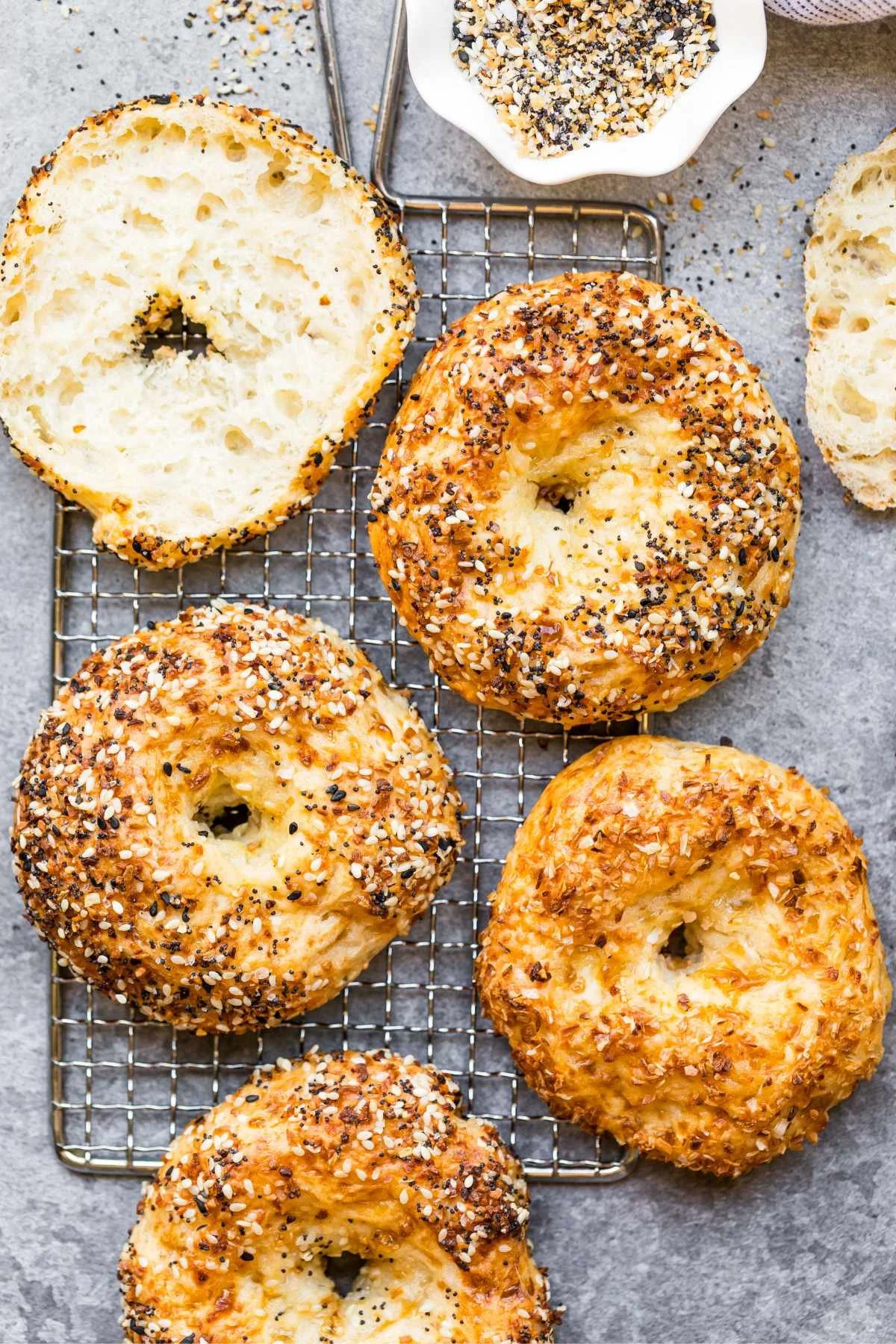 Baked protein bagels topped with cottage cheese on a wooden cutting board.