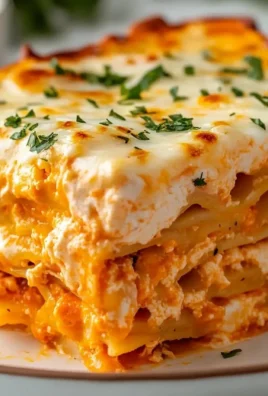 Cheesy Buffalo Ranch Chicken Lasagna topped with melted cheese and herbs