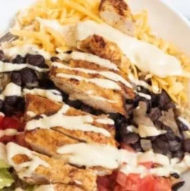 Delicious Chicken Burrito Yumm Bowls ready to eat, filled with fresh ingredients.