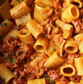 Creamy chorizo pasta dish served in a bowl, garnished with herbs.