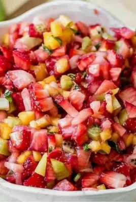 Bowl of fresh fruit salsa with colorful fruits and cinnamon sugar chips on the side.