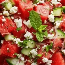 Fresh watermelon salad topped with feta cheese and mint leaves