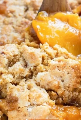 Gluten-free peach cobbler fresh out of the oven, topped with a scoop of vanilla ice cream.