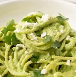 Plate of Green Spaghetti topped with creamy poblano sauce and herbs.