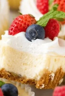 Irresistible mini cheesecakes topped with whipped cream and fresh fruit.