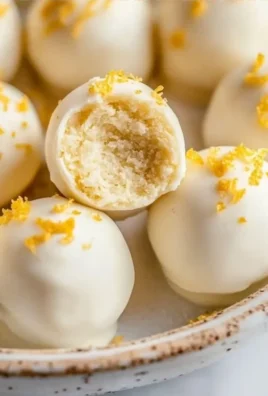 Lemon Oreo Truffles on a white plate with a slice of lemon