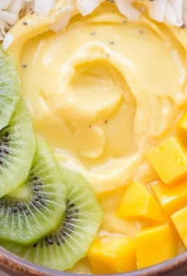Mango Pineapple Smoothie Bowl topped with fresh fruit and nuts