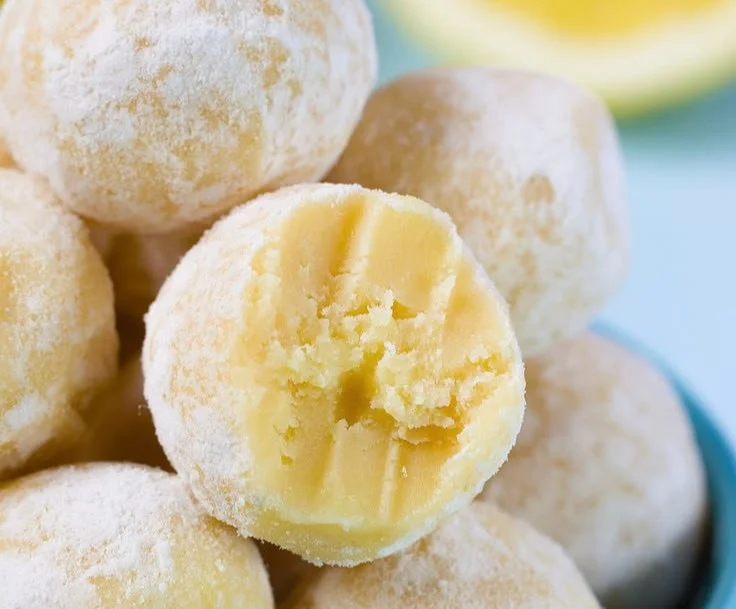 No bake lemon truffles dessert on a white plate with lemon slices