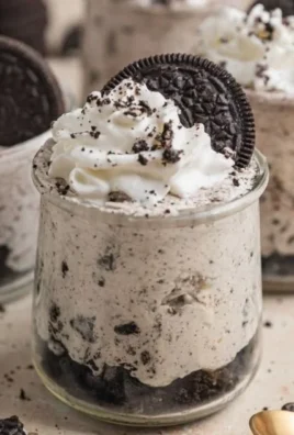 No Bake Oreo Cheesecake Cups served in dessert cups with Oreo cookie toppings.