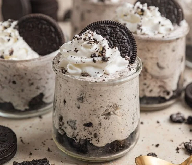 No Bake Oreo Cheesecake Cups served in dessert cups with Oreo cookie toppings.