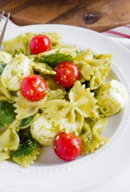 Bowl of Pesto Caprese Pasta Salad with fresh ingredients.