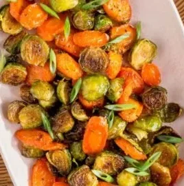 Bowl of roasted Brussels sprouts and carrots, a colorful and healthy side dish.