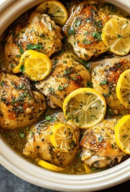Plate of slow cooker lemon garlic chicken garnished with fresh herbs